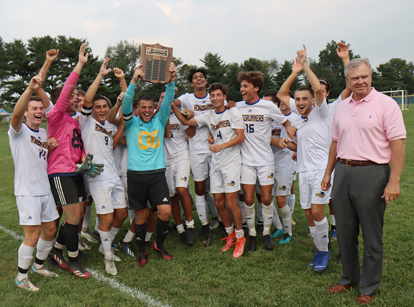 President Frederick Keating celebrates the Rowan College of South Jersey–Gloucester Road Runners Men’s Soccer team after they de